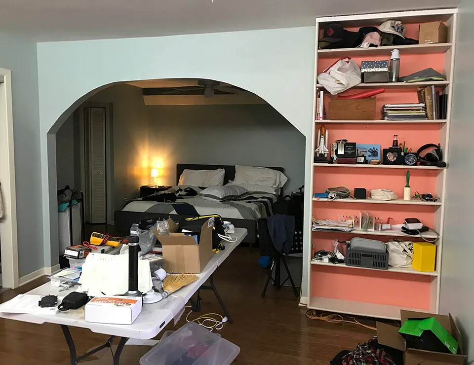 Bedroom before the remodel, with a pink bookshelf beside an arched doorway