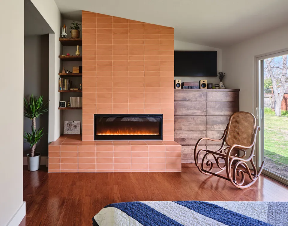 Bedroom with a coral tile fireplace, a wood dresser and a rocking chair