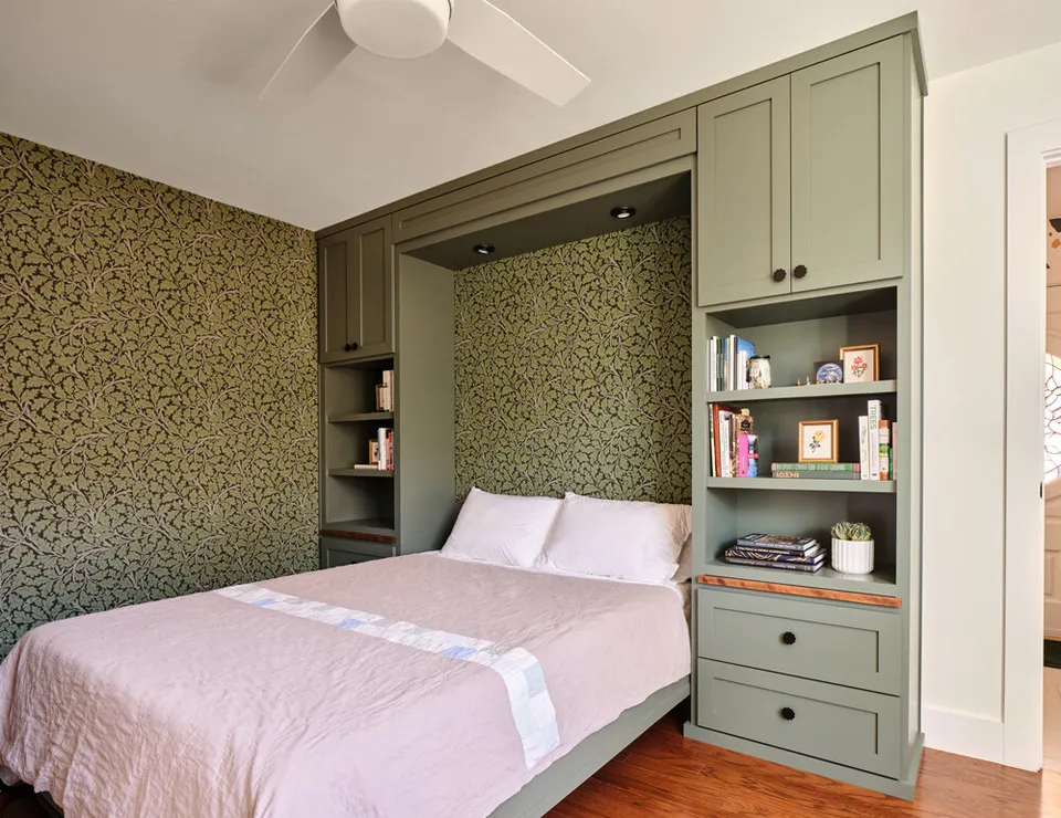 Bedroom after the remodel, with a sage green Murphy bed wall and built-in shelves
