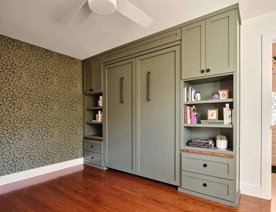 Sage green Murphy bed cabinet closed, with built-in shelves