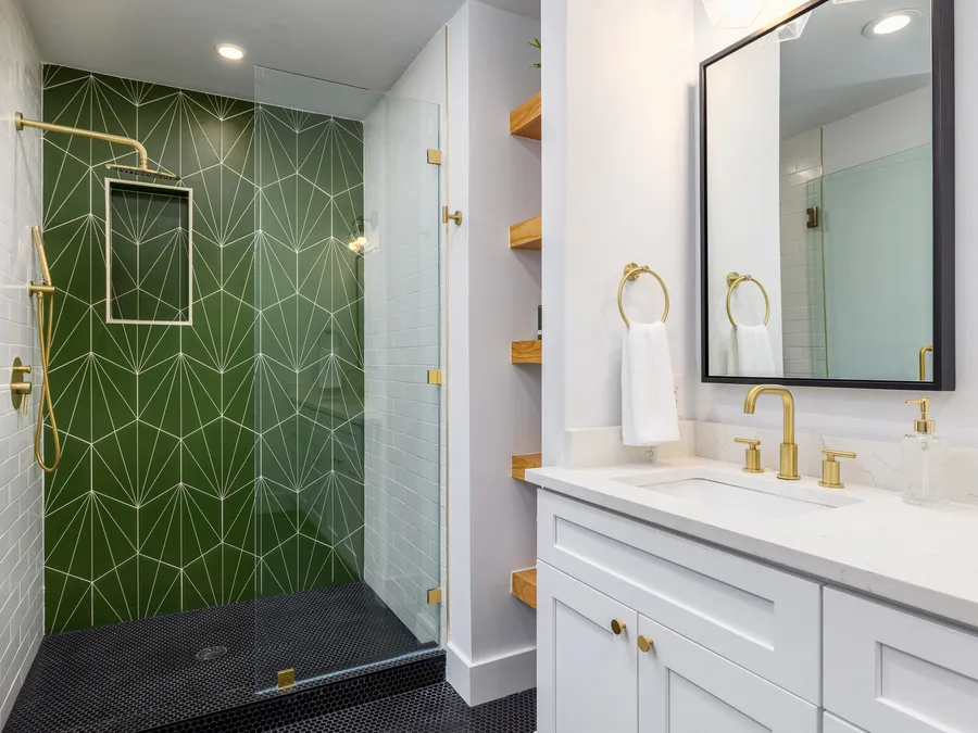 Bathroom with green tile shower and brass fixtures