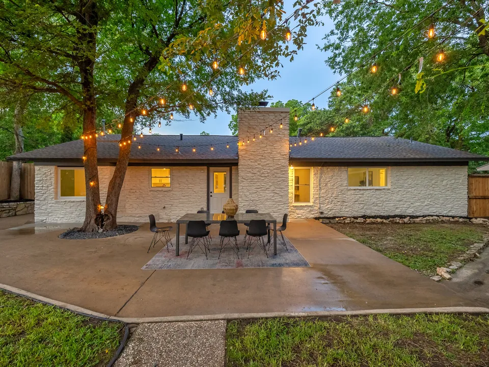 Patio with an outdoor dining table and string lights at dusk