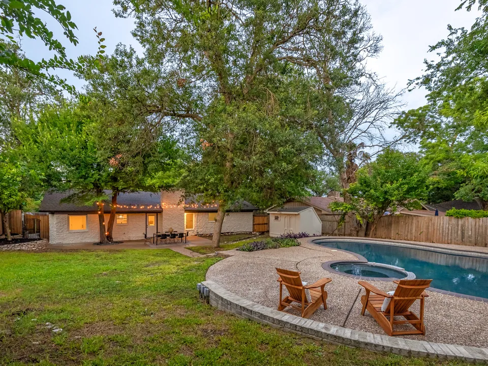 Pool and spa with the house and string lights beyond