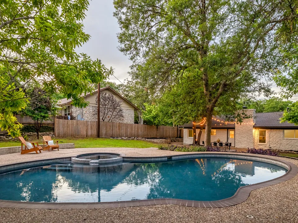 Refinished kidney-shaped pool with a spa and new coping in the backyard
