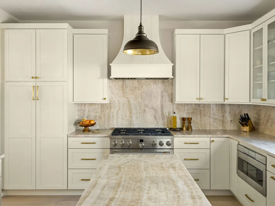 Cream shaker kitchen with a plaster range hood, a black pendant and quartzite counters