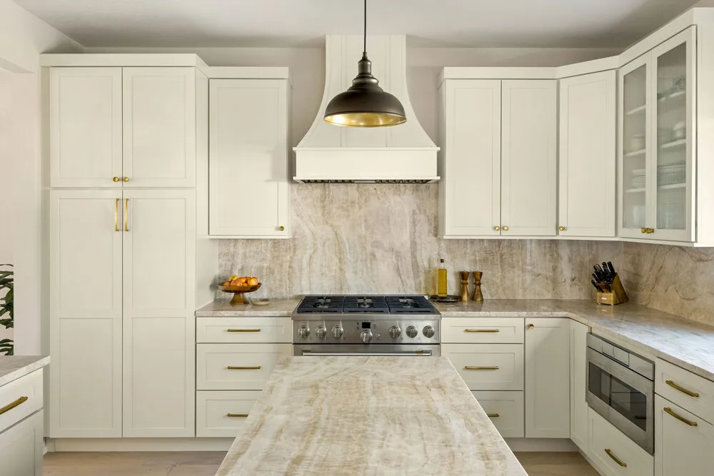 Cream shaker kitchen with a plaster range hood, a black pendant and quartzite counters