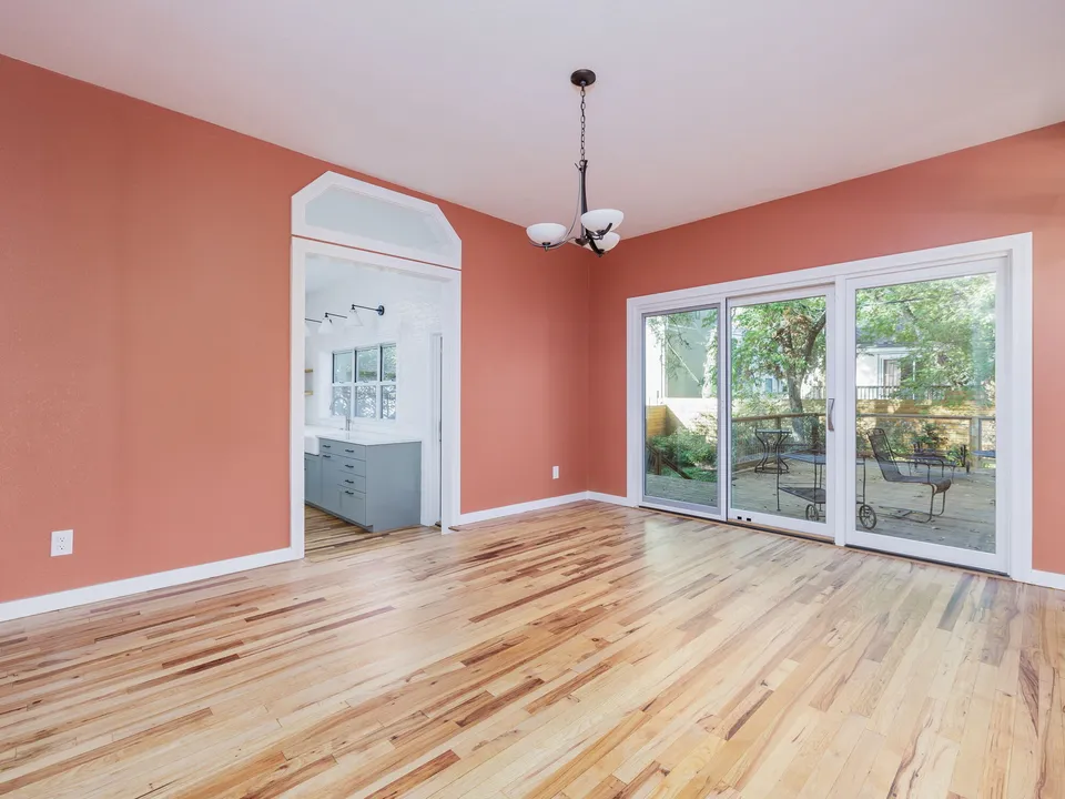 Dining room with coral walls, a chandelier and sliding glass doors to the patio