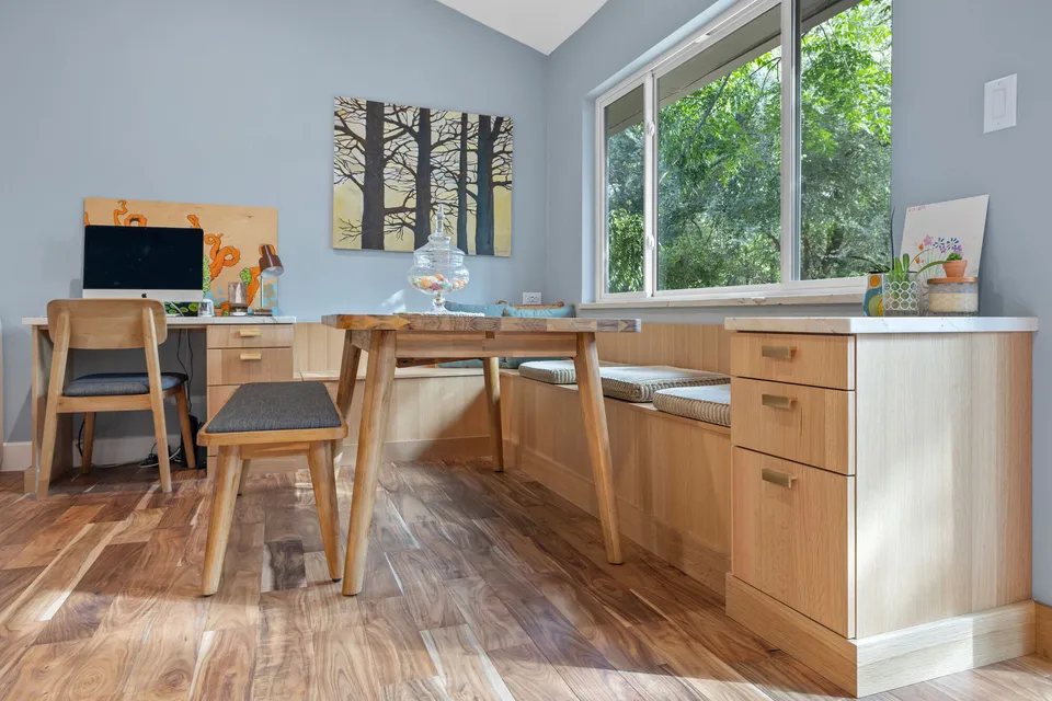 Built-in white oak booth seating and a custom table below a window