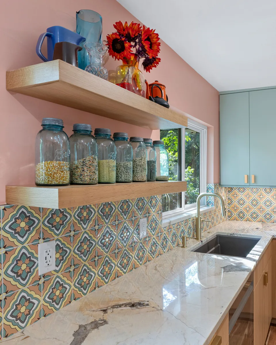 Floating oak shelves with glass jars above a patterned tile backsplash