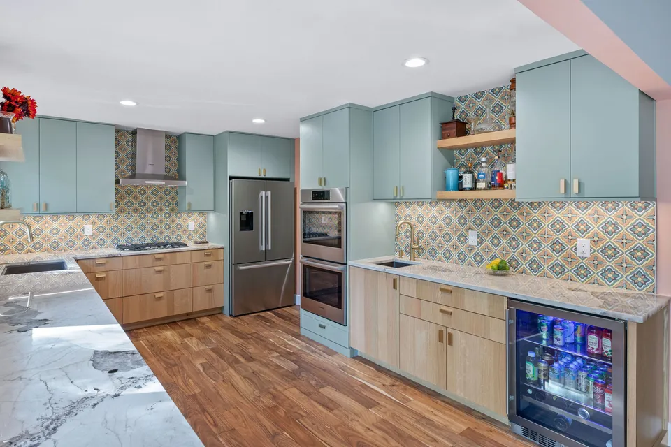 Kitchen with sage uppers, white oak lowers, double ovens and a beverage fridge