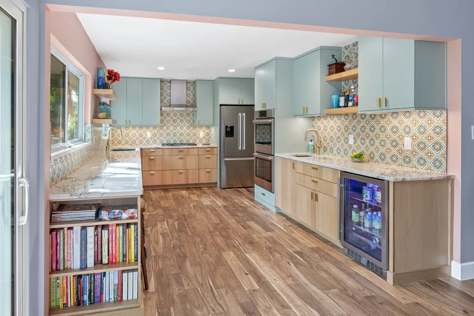 White oak cabinets with a beverage fridge, a bookshelf end and patterned tile