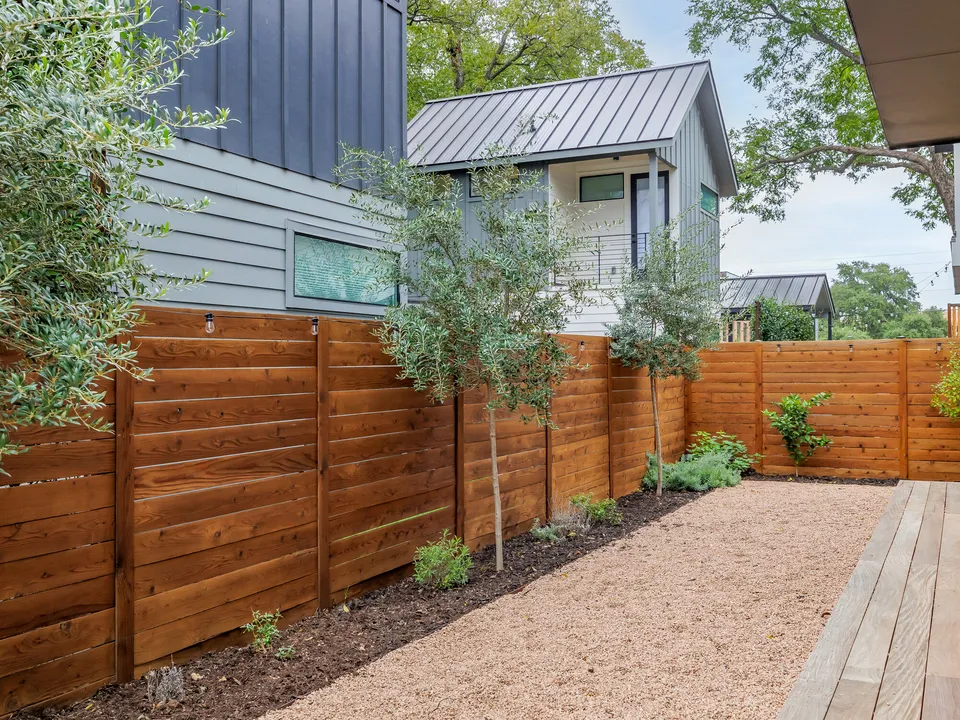 Backyard with a cedar privacy fence, gravel and a wood deck