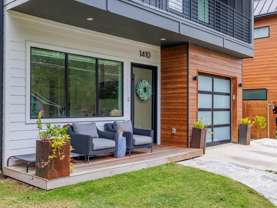 Front porch with a planter, blue chairs and a wreath on the door