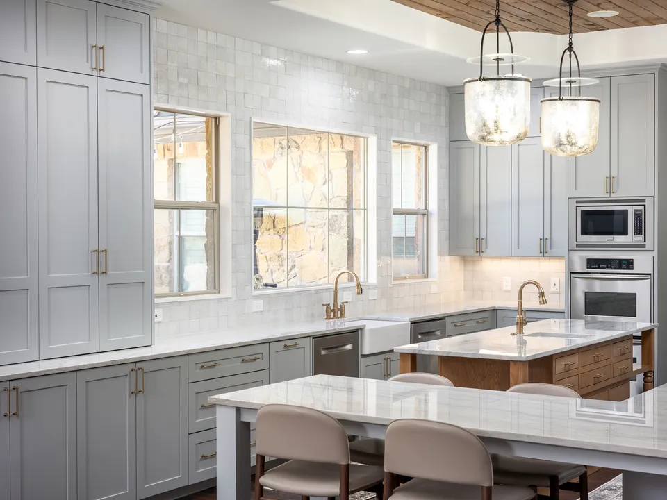 Tall grey pantry cabinets beside the sink wall and a dining table