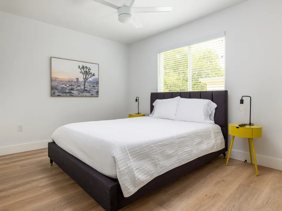 Bedroom with a black upholstered bed and a yellow side table
