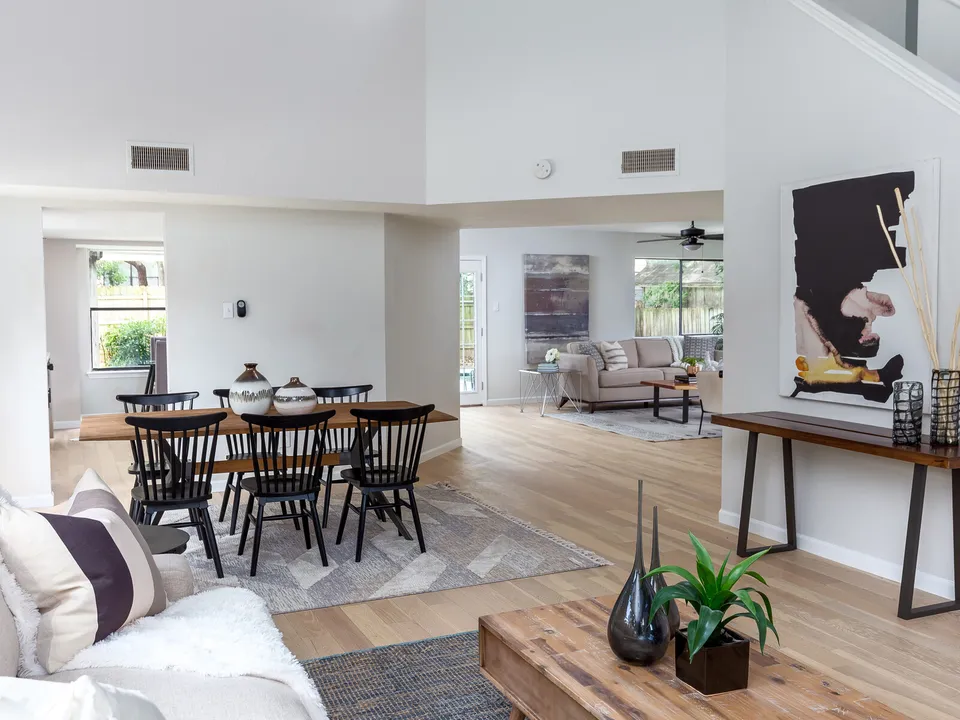 Open living and dining area with black Windsor chairs