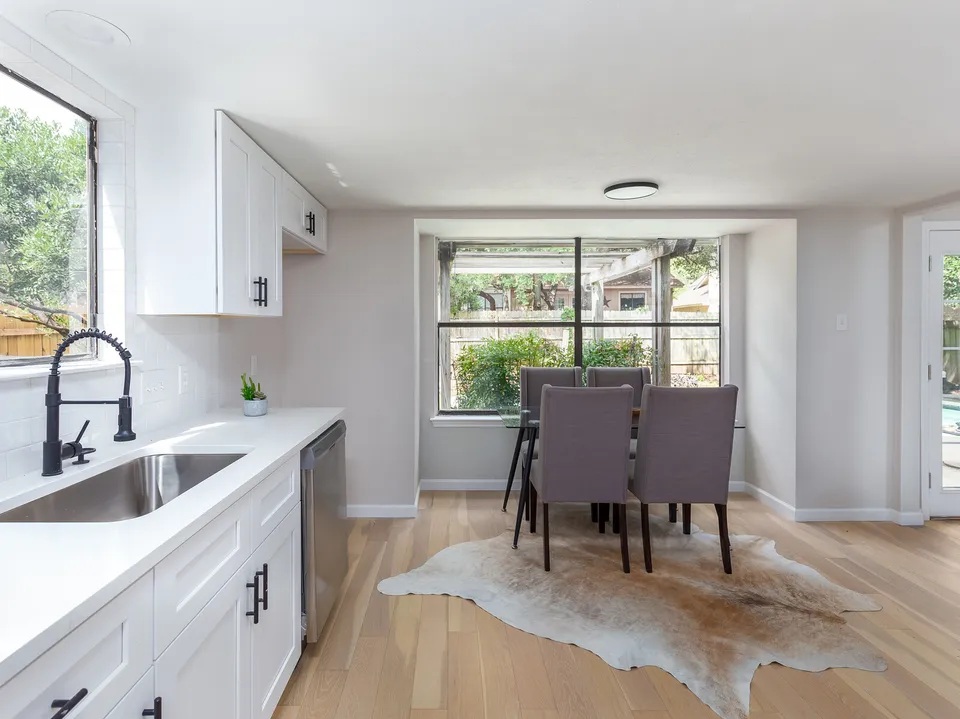 Sink run with a black faucet looking toward the dining area and cowhide rug