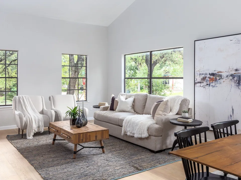Sitting area with a sofa, armchairs and tall black-framed windows
