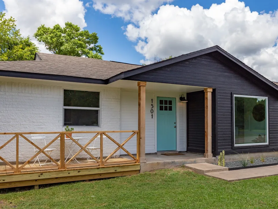 Front porch with a cedar X railing, cedar posts and an aqua front door
