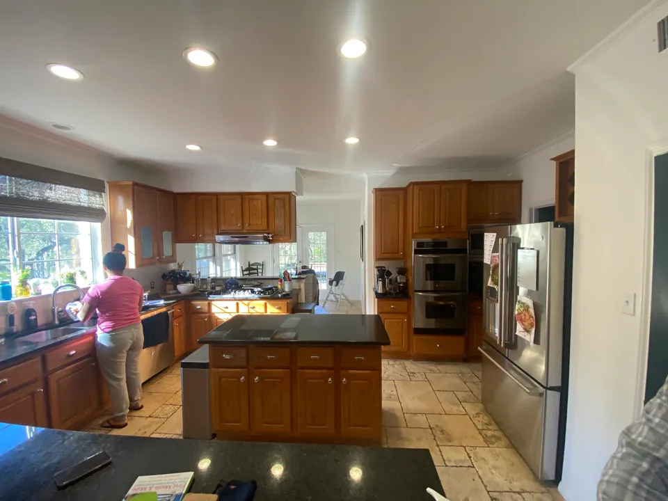 Kitchen before the renovation, with cherry cabinets, black counters and a stone tile floor