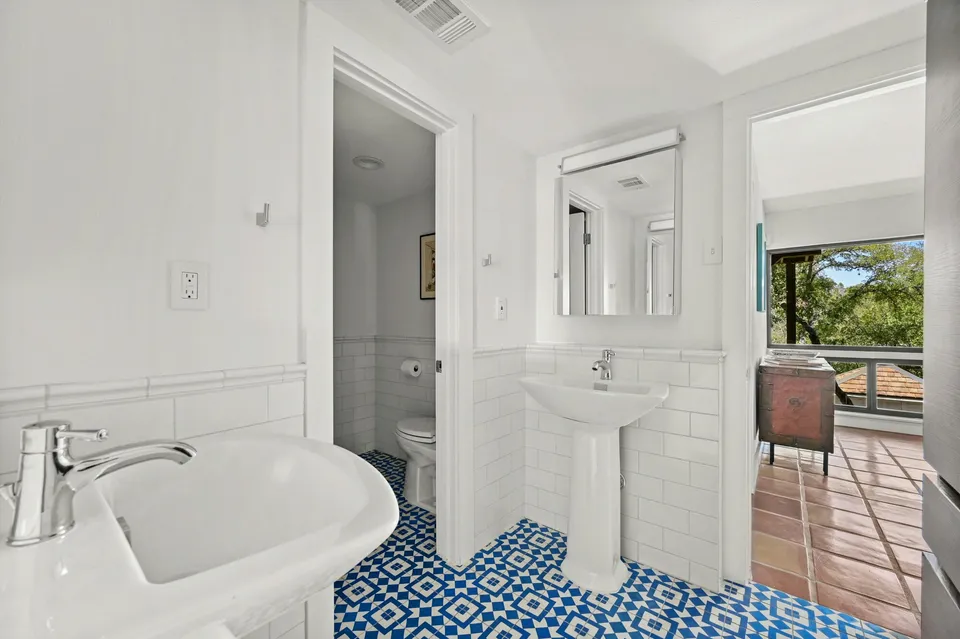 Bathroom with a pedestal sink and blue patterned floor tile