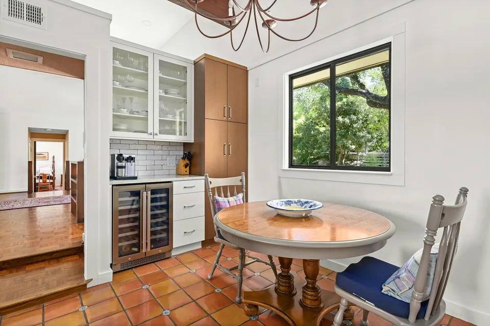 Breakfast nook with a round table, a wine fridge and wood cabinets