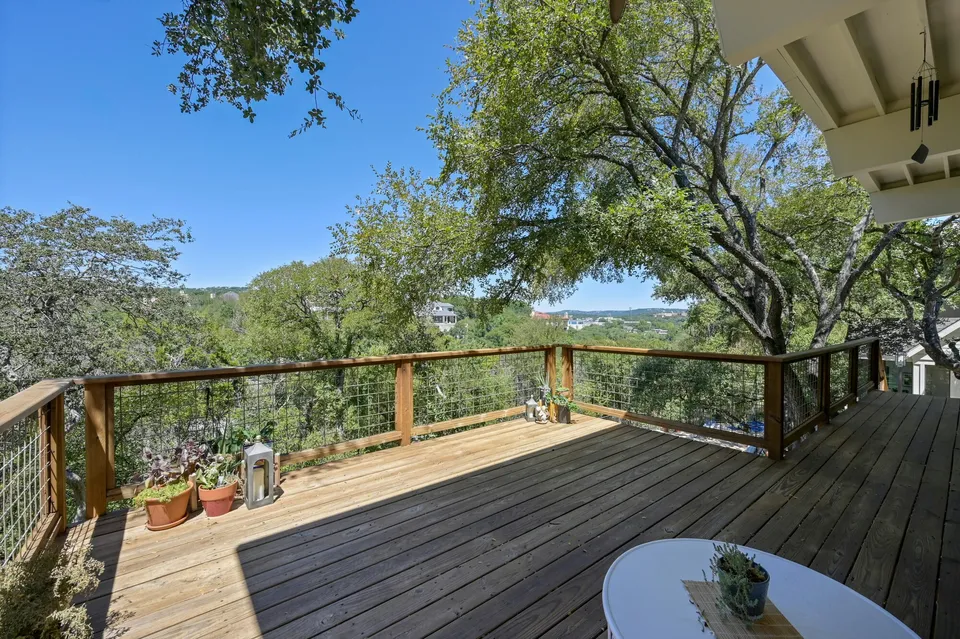 Deck with a cable railing looking out over the trees to Lake Austin