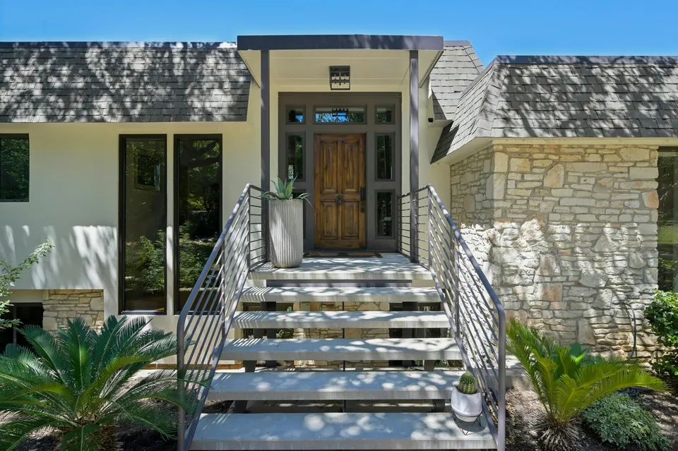 Front entry with metal stairs to a wood door