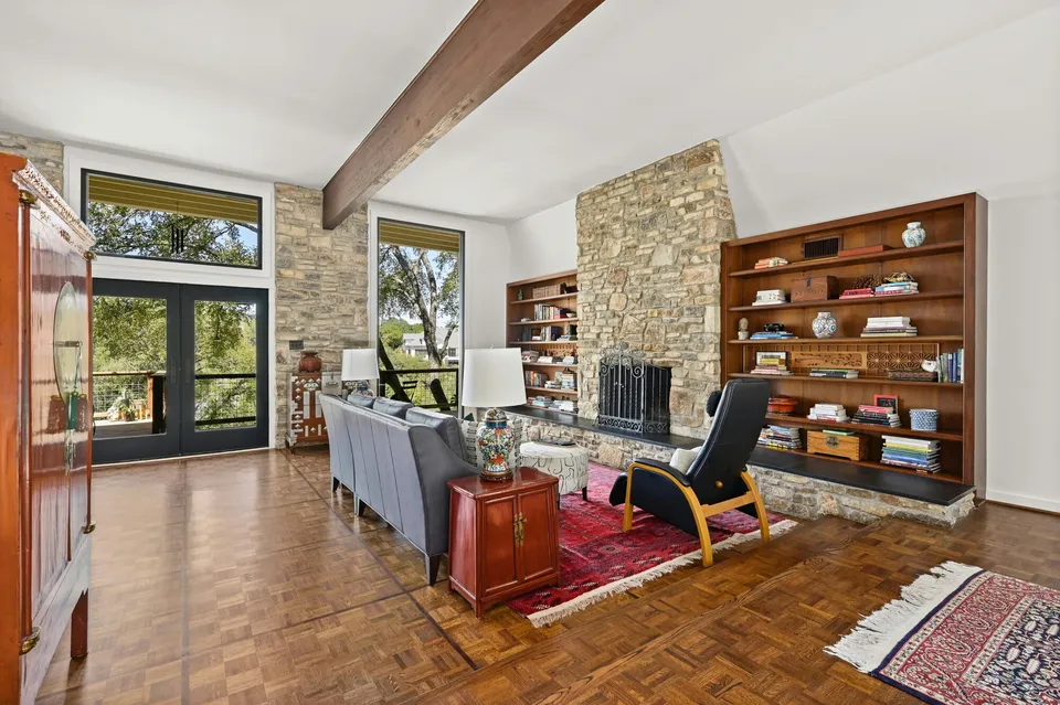 Living room with built-in bookshelves and a stone fireplace