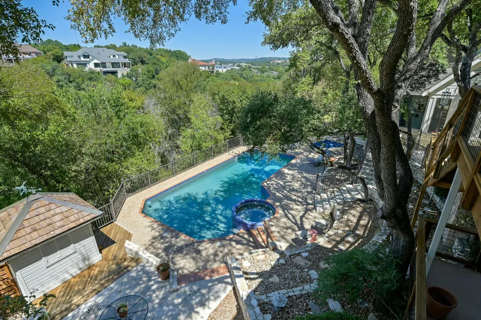 Pool and spa below the house among oak trees