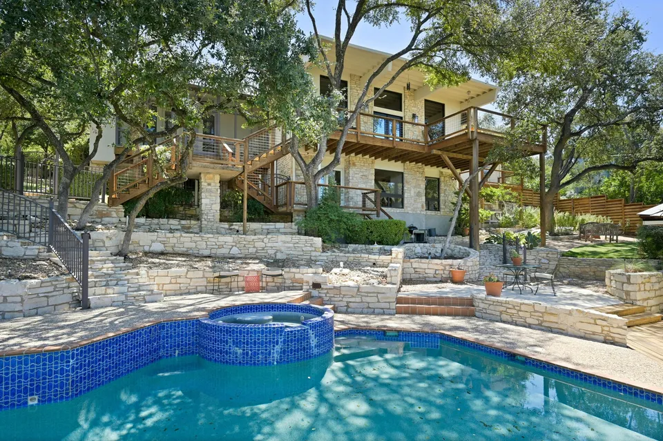 Pool and spa with stone terraces and the house above
