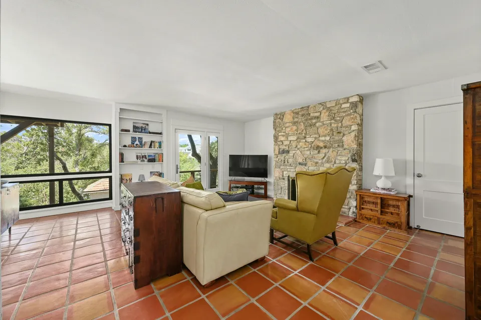 Second living room with a stone fireplace and armchairs