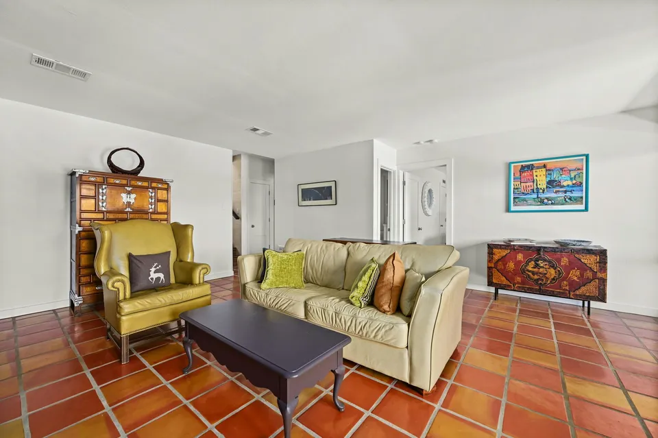 Sitting room with a yellow wingback chair and a cream sofa