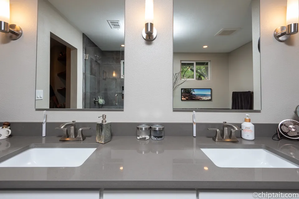 Grey quartz double vanity with two mirrors and wall sconces