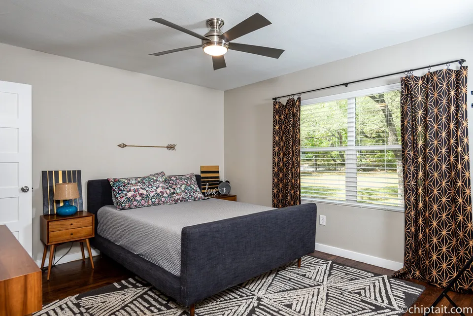 Guest bedroom with a navy bed and patterned curtains