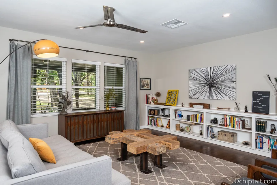 Living room with built-in bookshelves, a grey sofa and a wall of windows