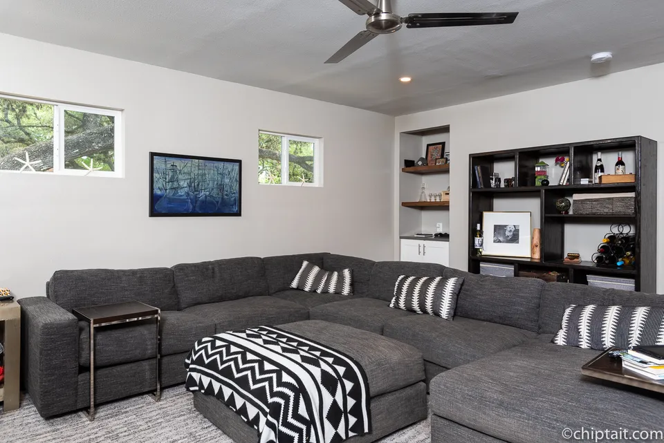 Media room with a large grey sectional and black shelving