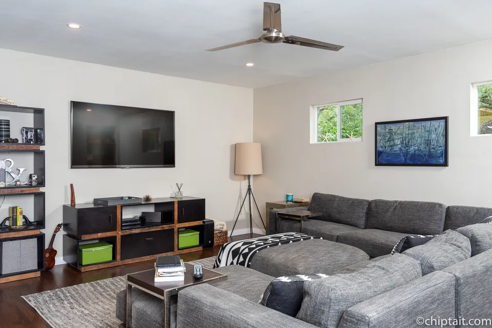 Media room with a TV above a low media console
