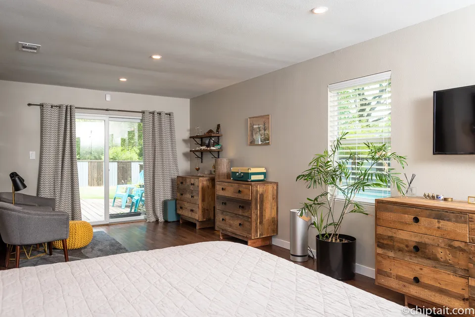 Primary bedroom with reclaimed wood dressers and sliding doors