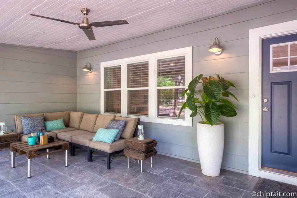 Screened front porch with outdoor sofas and a blue front door