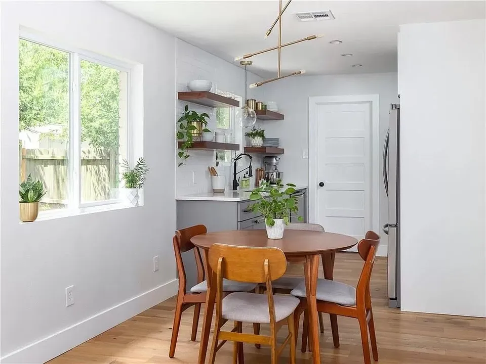 Dining nook with a round wood table and a brass chandelier
