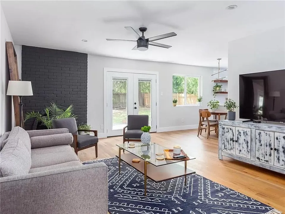 Living room with a black brick fireplace and a patterned navy rug