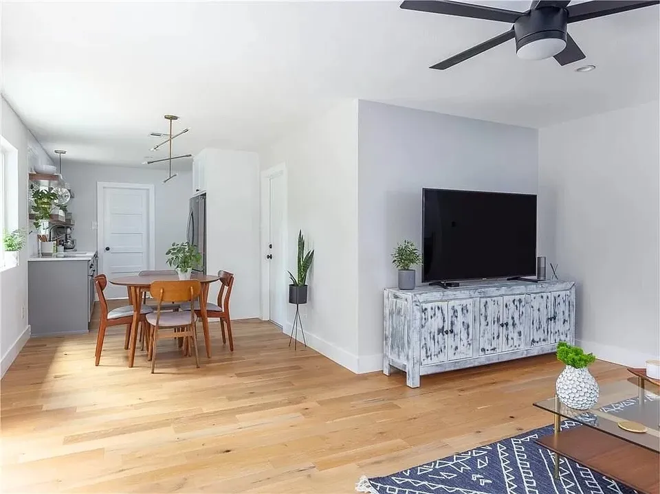 Open dining and living area with a TV and a round table