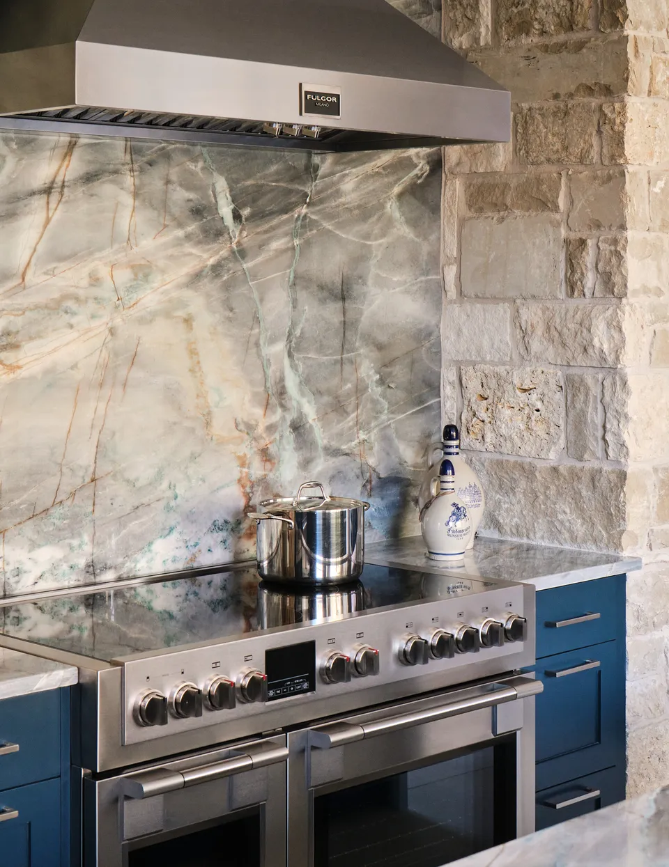 Range and quartzite slab backsplash in a limestone surround