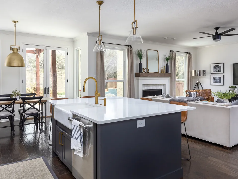 Charcoal island with a farmhouse sink, open to the living room and fireplace