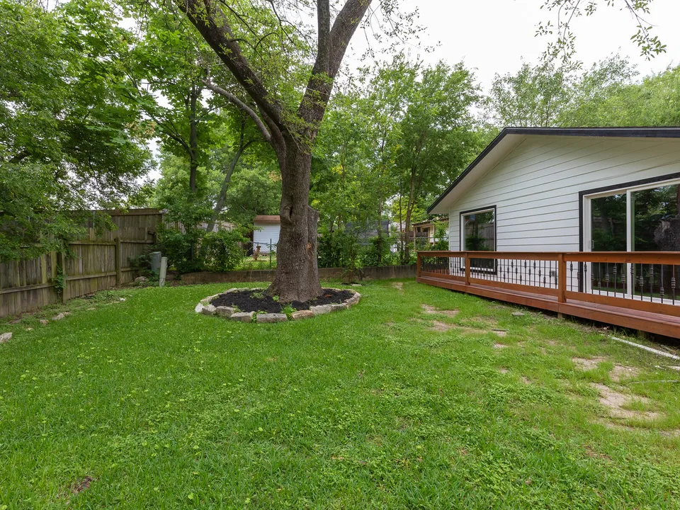 Backyard with a large tree and a new deck along the house