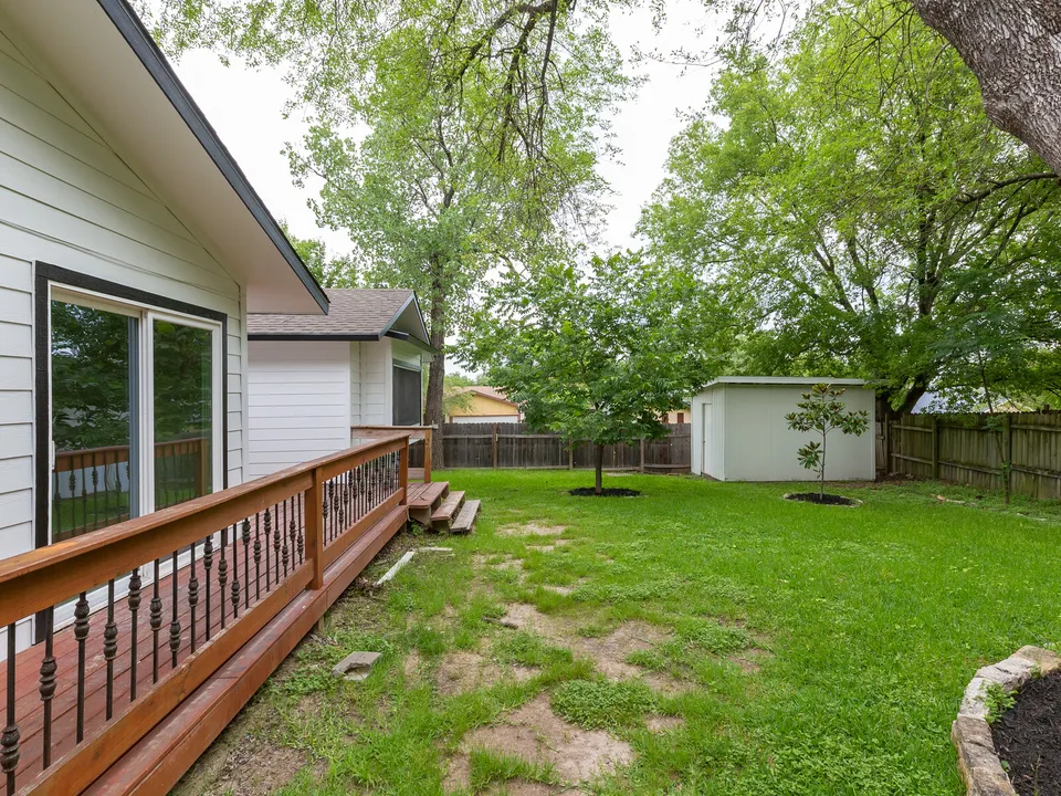 Deck railing along the house looking out to the yard and shed