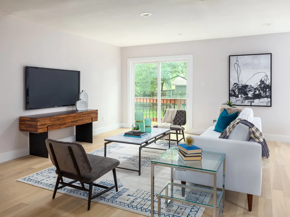 Living room with a TV on a wood console and a white sofa