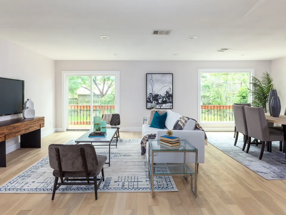 Living room with a white sofa, a glass coffee table and sliding doors to the deck