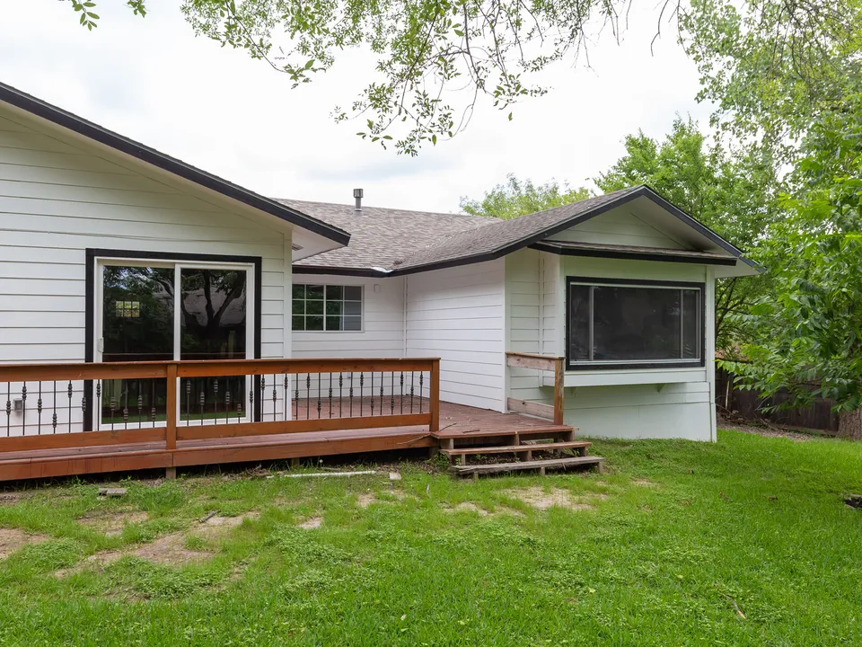 New deck with an iron railing along the back of the house